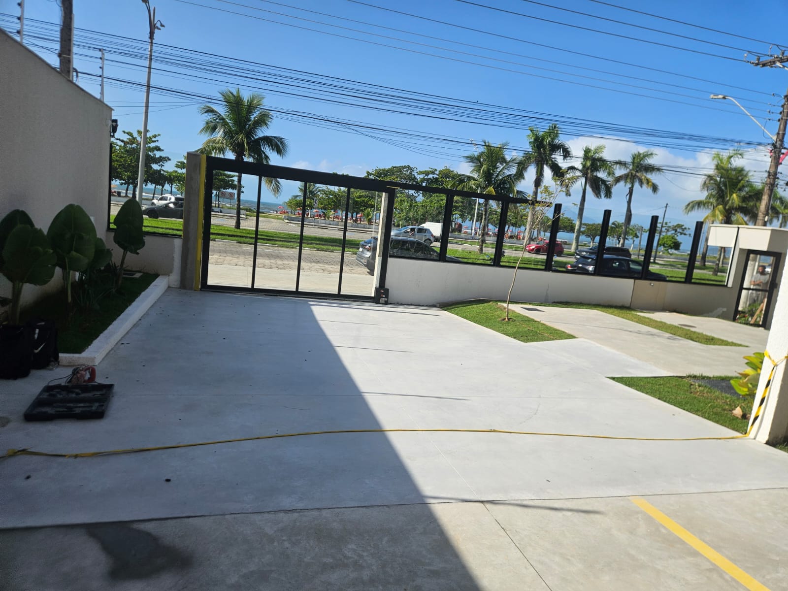 Área de acesso concluída com piso de concreto e paisagismo